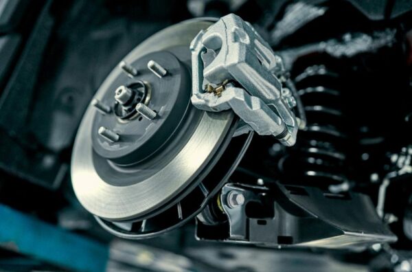 car brake inspection showing worn brake pads and rotor damage signs